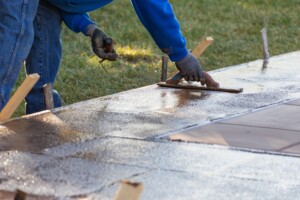 Construction Worker Smoothing Wet Cement With Trowel Tools