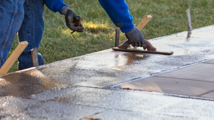 Construction Worker Smoothing Wet Cement With Trowel Tools